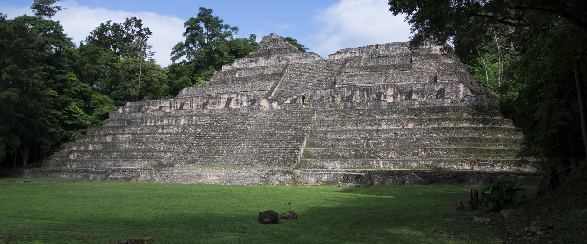 Ancient Mayan pyramid surrounded by lush jungle in Belize, showcasing historical architecture and ar.