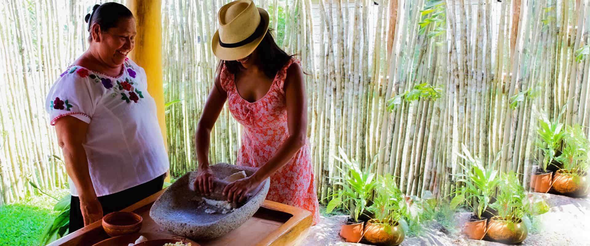 Women preparing traditional Belizean dish in a rustic kitchen setting.